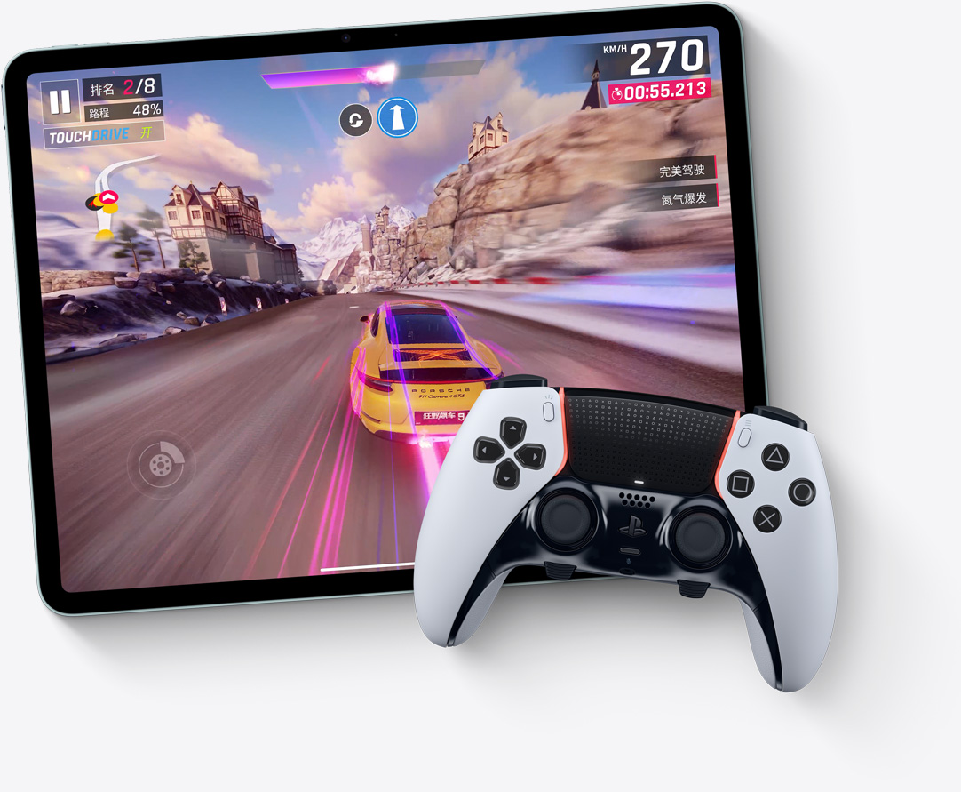 横屏放置的 iPad Air，屏幕显示游戏《狂野飙车9：竞速传奇》的画面，旁边有 Playstation 手柄。