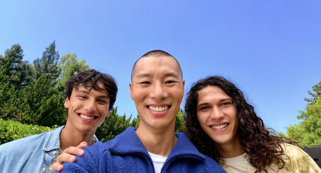 两部白色 iPhone 17 局部重叠，展示前置摄像头和后置融合式双摄，屏幕画面为使用长焦功能拍摄的蒲公英超高分辨率特写。