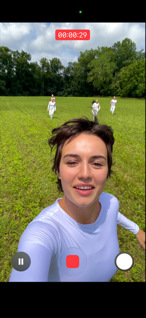 iPhone 17 Pro 屏幕显示一个人迎风起舞的自拍视频，展示视频超稳防抖功能。