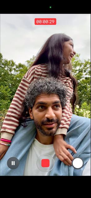 iPhone 17 屏幕展示视频拍摄防抖功能，画面是一位男士将一位小女孩背在自己的双肩上。