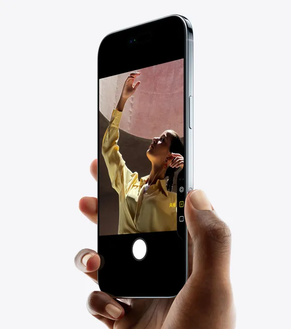一只手拿着 iPhone Air，拇指放在相机控制按钮上，以正面斜侧外观展示纤薄外形、灵动岛和侧边按钮。