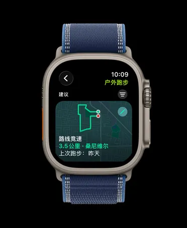 Apple Watch Ultra 3，展示原色钛金属表壳、路线竞速、户外跑步体能训练，搭配蓝配亮蓝色野径回环式表带。